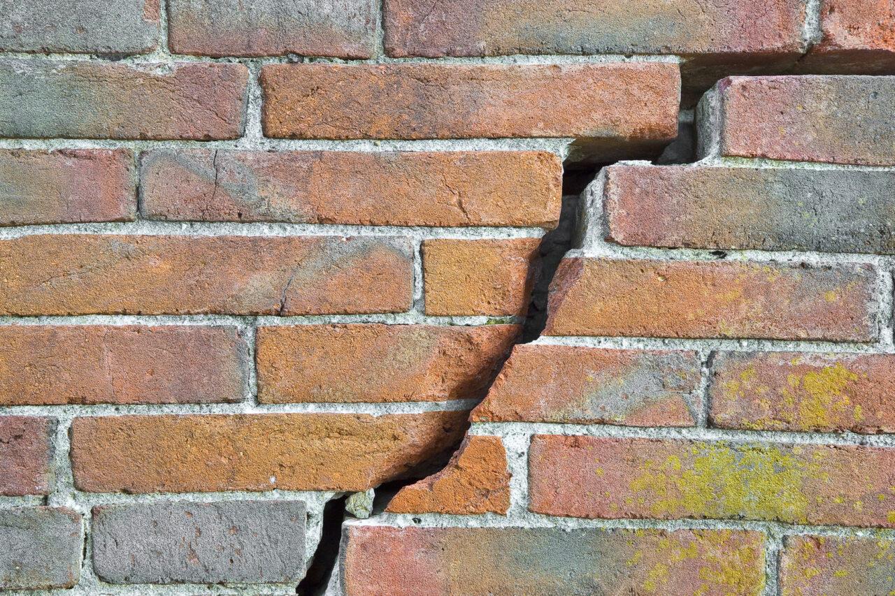 Dangerous old exposed cracked brick wall
