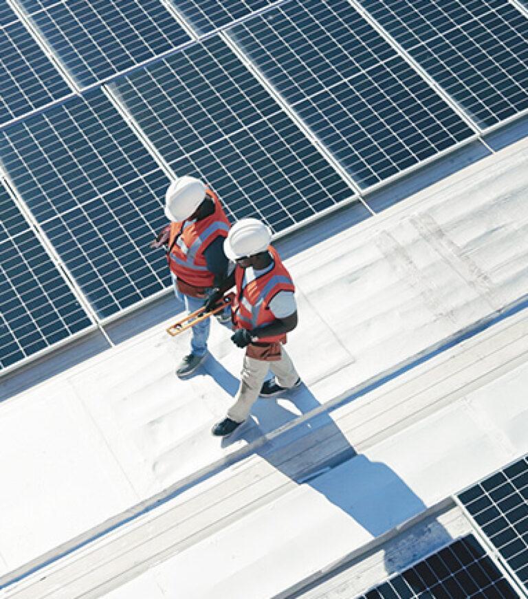 Two workers walking, wearing high visibility vests